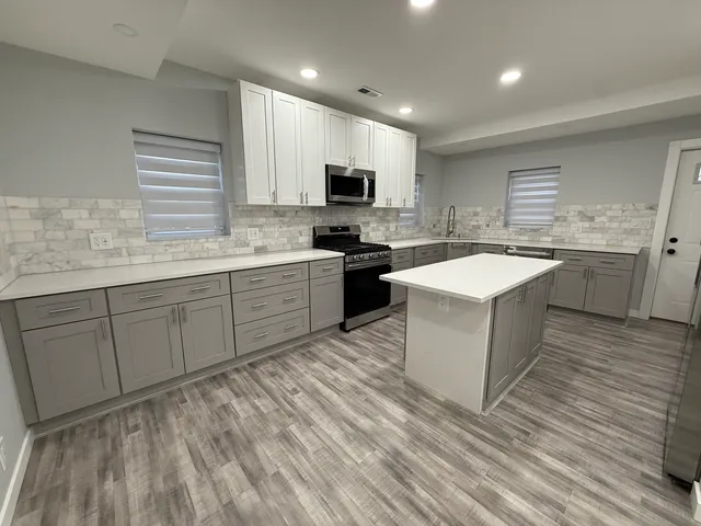 a kitchen with a sink stove and cabinets