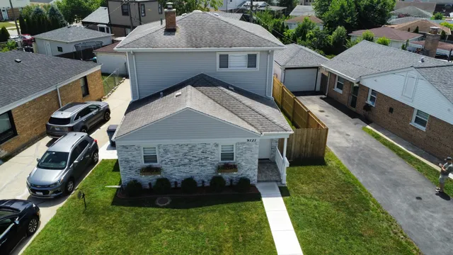 a aerial view of a house with a yard table and chairs