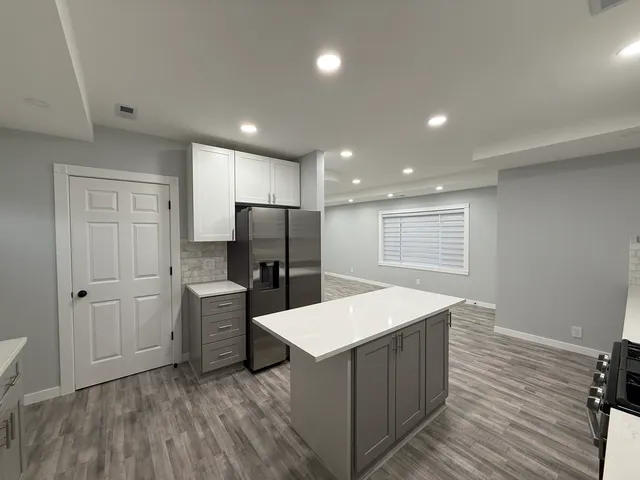 a kitchen with stainless steel appliances a refrigerator and wooden floor