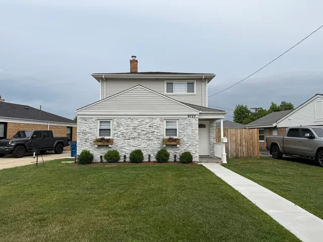 a front view of a house with a garden and trees