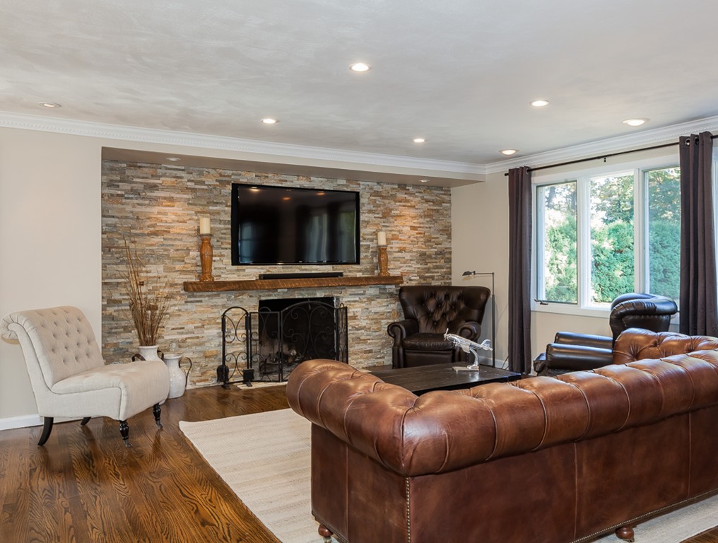 257 Captain Road Longmeadow, MA 01106 - Photo 9 of 30 a living room with furniture a fireplace and a flat screen tv
