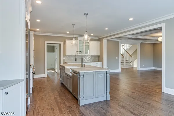 a kitchen with a sink and wooden floor