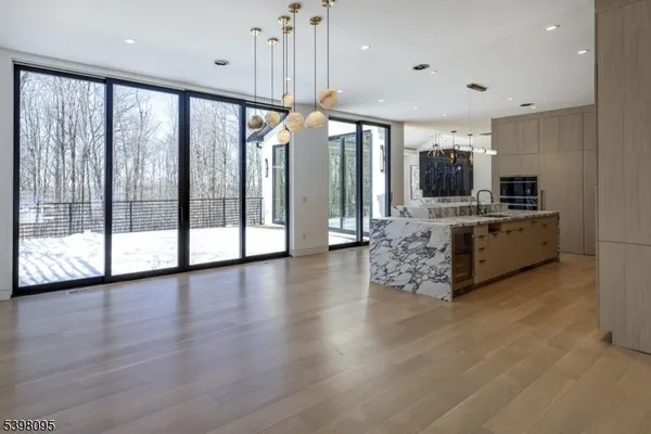 a large kitchen with stainless steel appliances granite countertop a large counter top a stove and a wooden floors