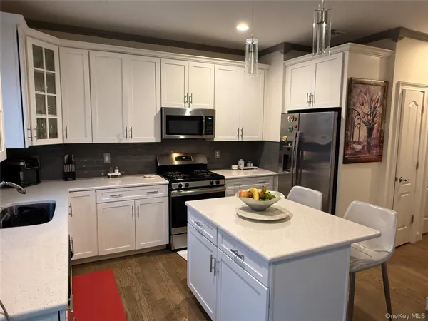 a kitchen with granite countertop a sink stove and refrigerator