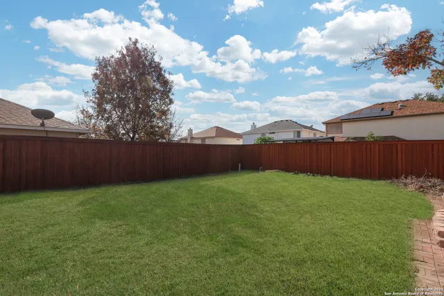 a view of backyard with wooden fence