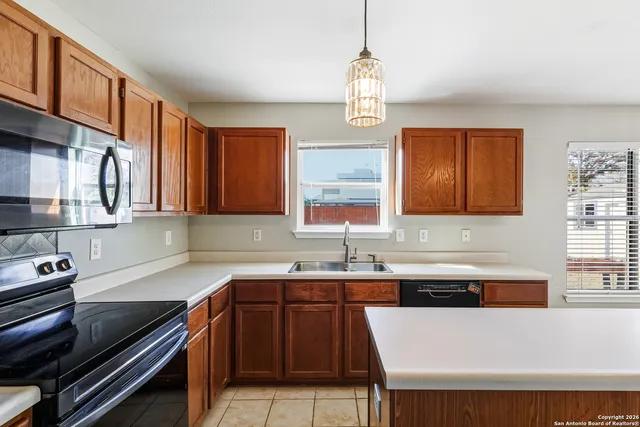 a kitchen with stainless steel appliances a sink stove and cabinets