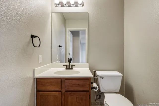 a bathroom with a toilet sink and mirror