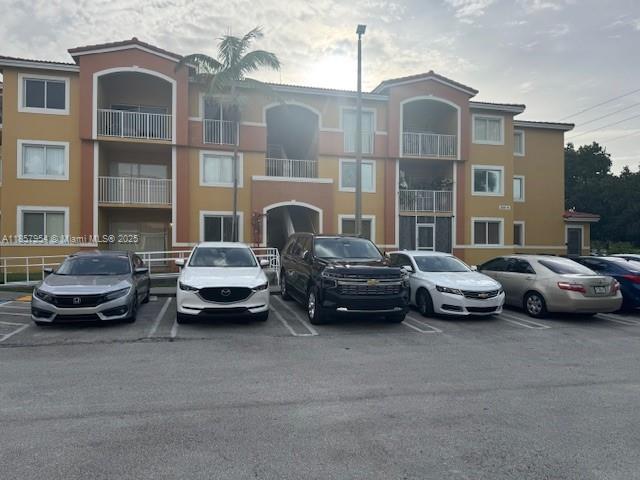 20810 Southwest 87th Avenue, Unit 308 Cutler Bay, FL 33189 - Photo 1 of 24 a couple of cars parked in front of a brick building
