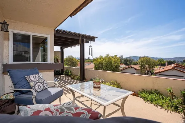 a view of a patio with couches table and chairs and potted plants