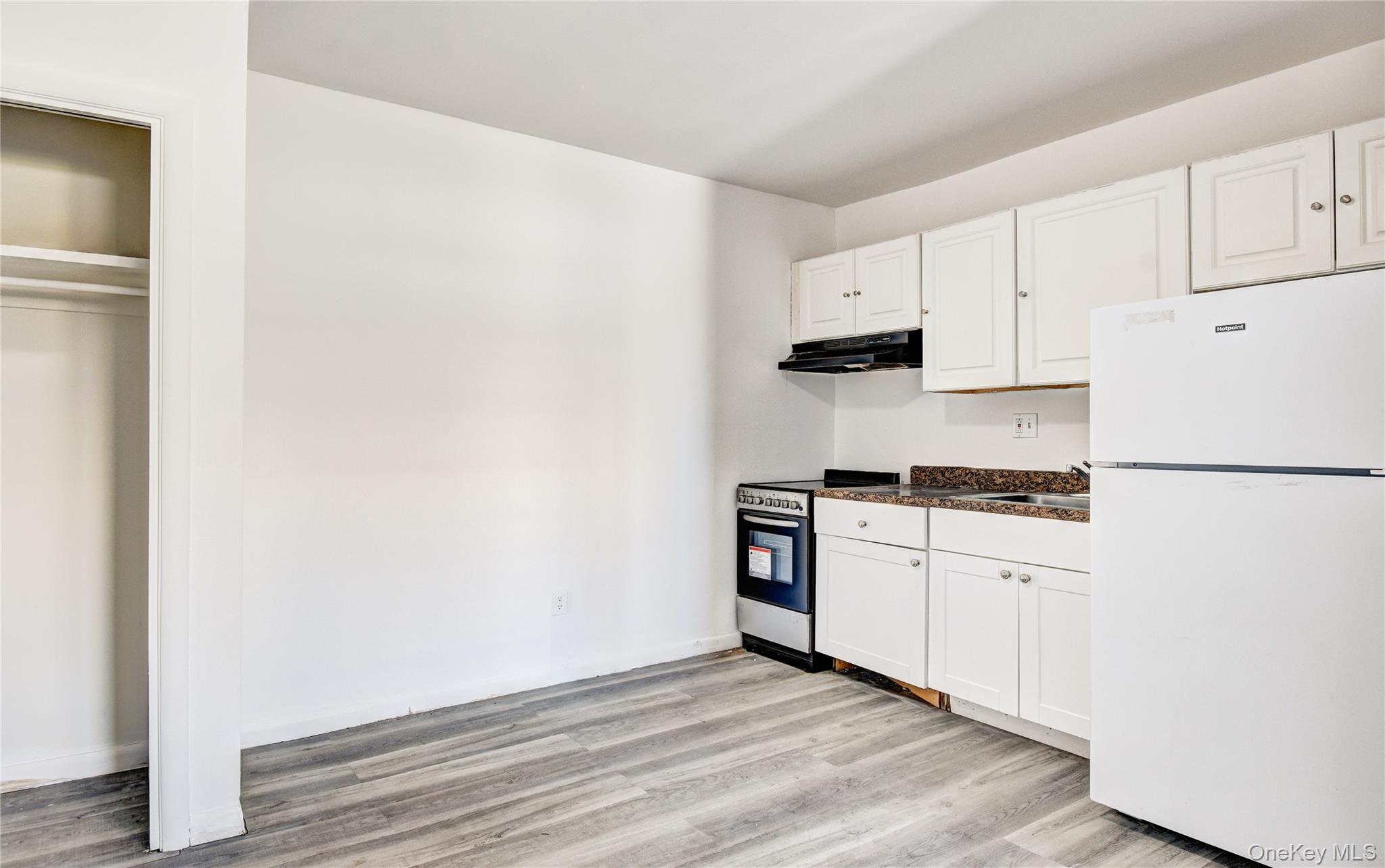 19 Gerald Drive, Unit B2 Poughkeepsie, NY 12601 - Photo 4 of 14 a kitchen with granite countertop white cabinets and white appliances