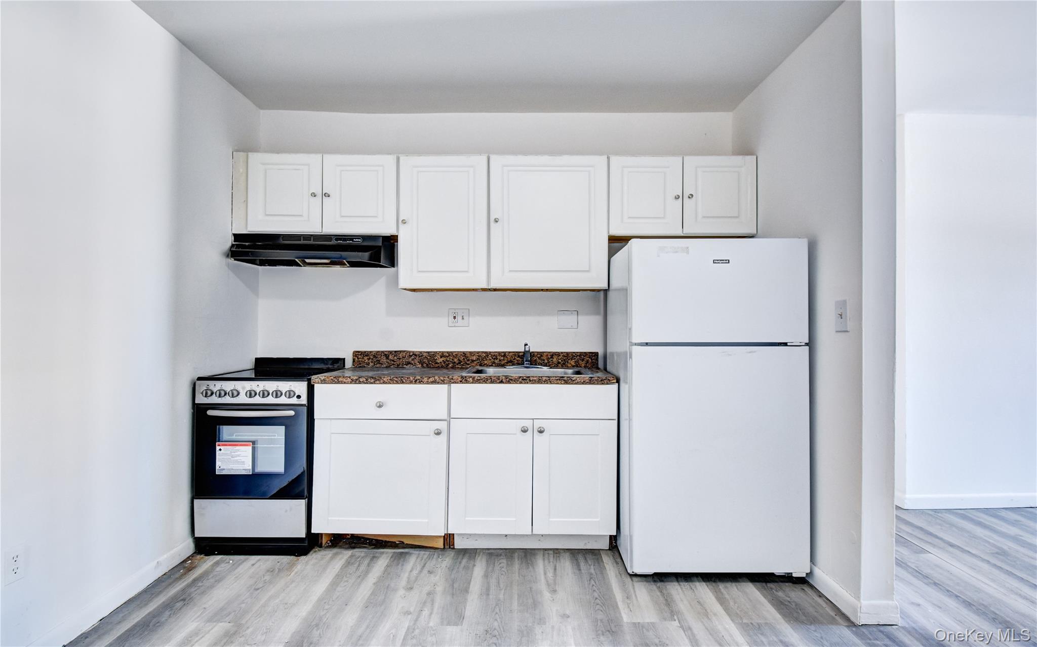 19 Gerald Drive, Unit B2 Poughkeepsie, NY 12601 - Photo 5 of 14 a kitchen with cabinets appliances and wooden floor
