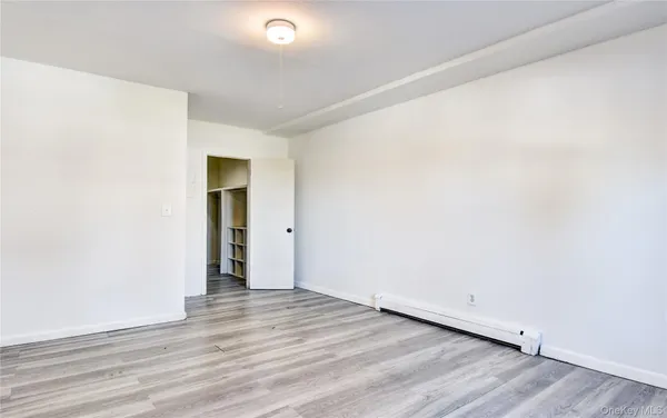 an empty room with wooden floor and closet