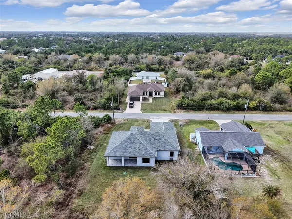 an aerial view of a house with swimming pool and big yard