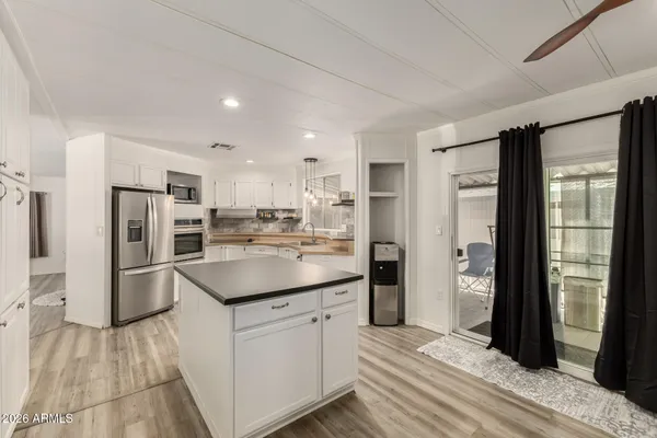 a kitchen with white cabinets and stainless steel appliances