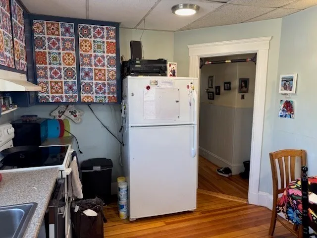 a view of kitchen with stainless steel appliances granite countertop refrigerator and wooden floor