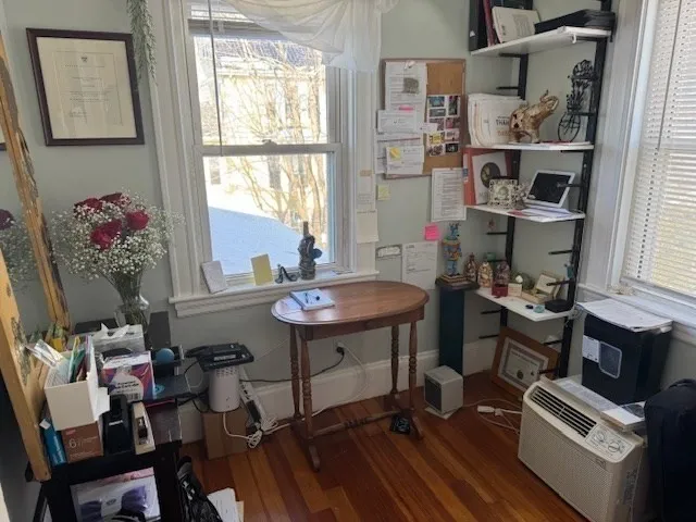 a view of a workspace with furniture and a window