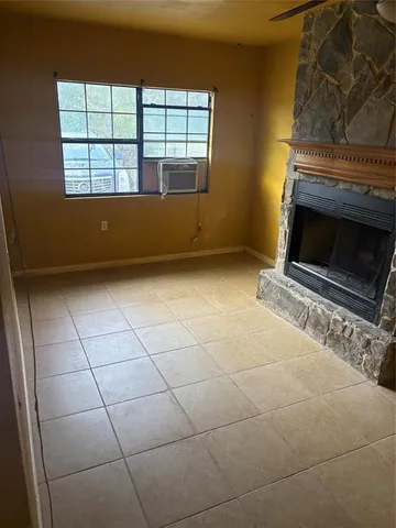 a view of an empty room with a fireplace and a window