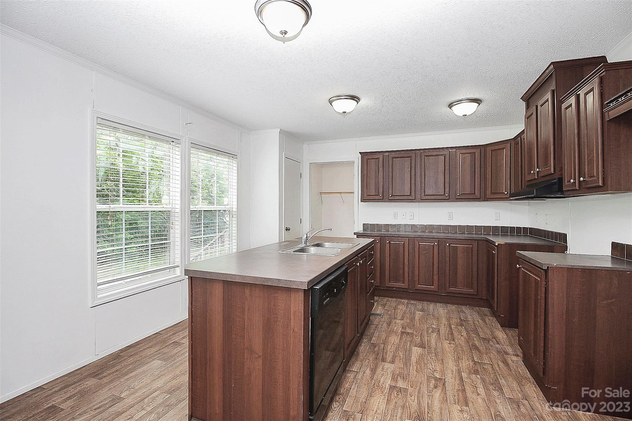 812 Margrace Road Kings Mountain, NC 28086 - Photo 21 of 34 a kitchen with kitchen island granite countertop wooden cabinets a stove a sink and dishwasher with wooden floor