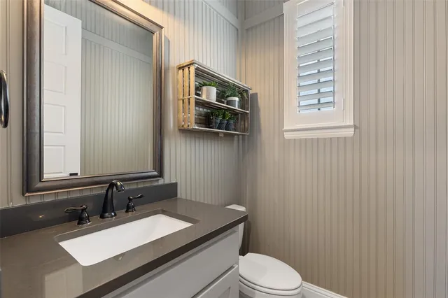 a bathroom with a sink a toilet and mirror