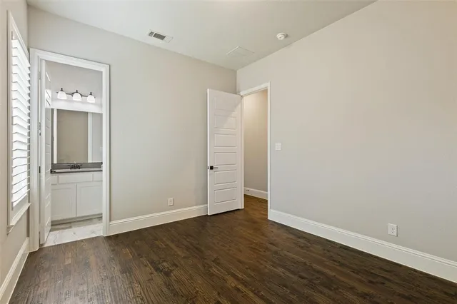 an empty room with wooden floor & closet area