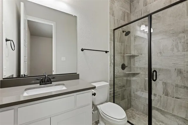 a bathroom with a granite countertop sink toilet and shower