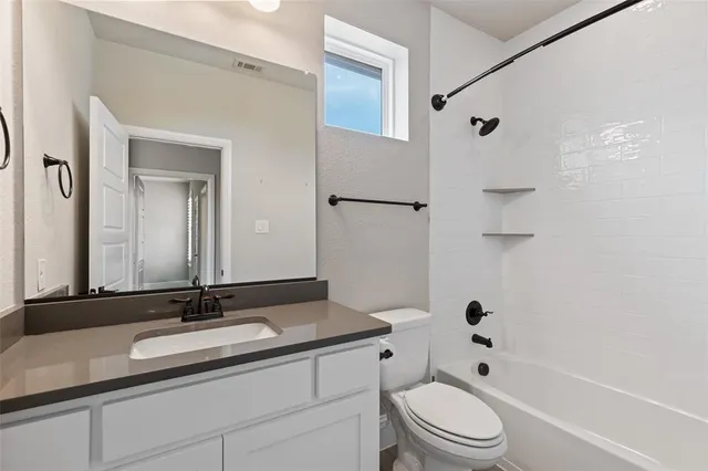 a bathroom with a granite countertop sink a toilet and a mirror