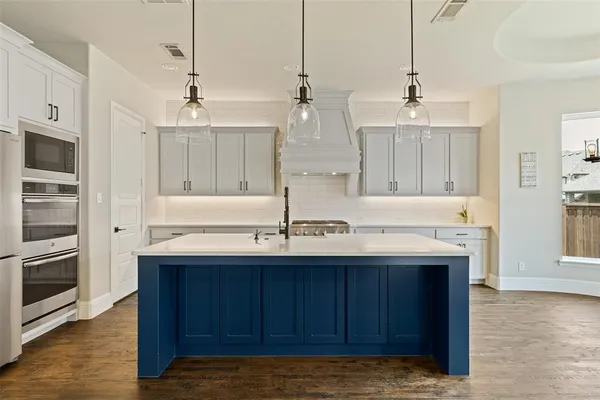 a kitchen with kitchen island granite countertop a sink and cabinets