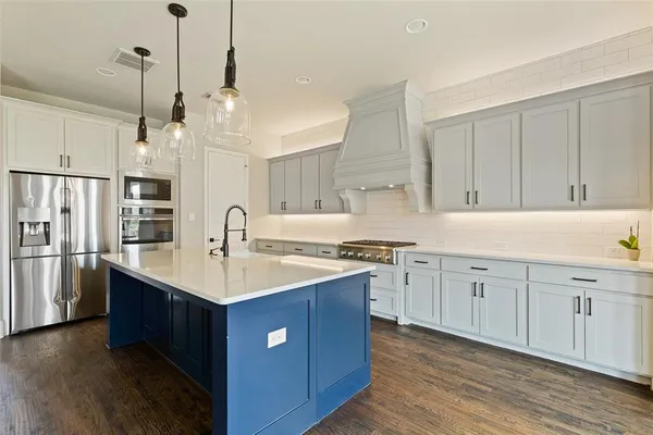 a kitchen with white cabinets appliances and sink