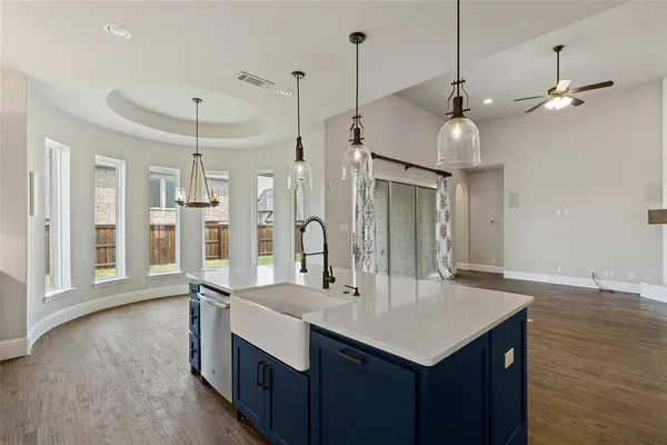 a kitchen with stainless steel appliances granite countertop a sink a refrigerator and a view of living room