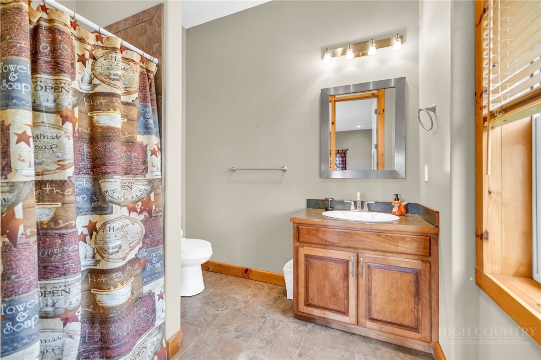 7994 3 Top Road Todd, NC 28684 - Photo 32 of 50 a bathroom with a granite countertop sink a toilet and a shower