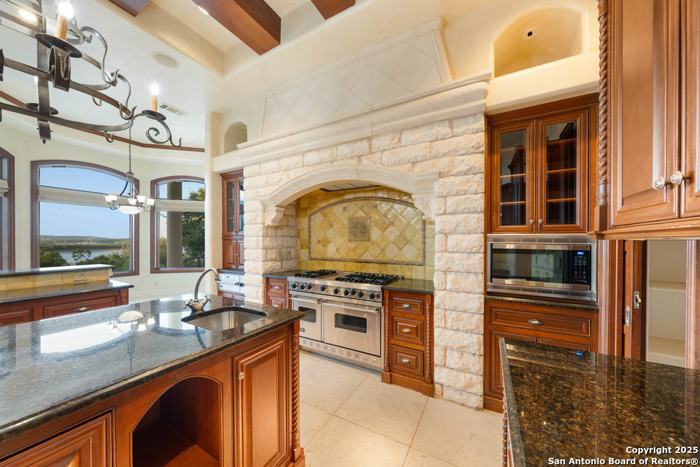 217 Bella Riva Drive Austin, TX 78734 - Photo 15 of 38 a kitchen with stainless steel appliances granite countertop a stove and a sink