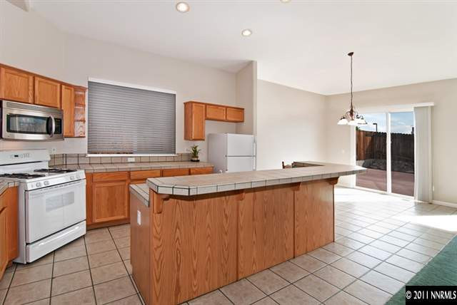 1462 Amston Road Reno, NV 89511 - Photo 7 of 13 a kitchen with stainless steel appliances granite countertop a sink and a stove