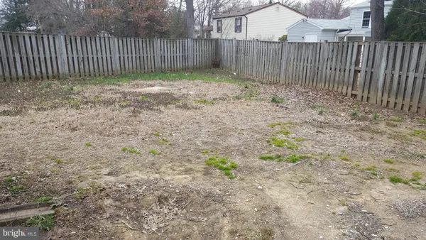 a view of a backyard with wooden fence