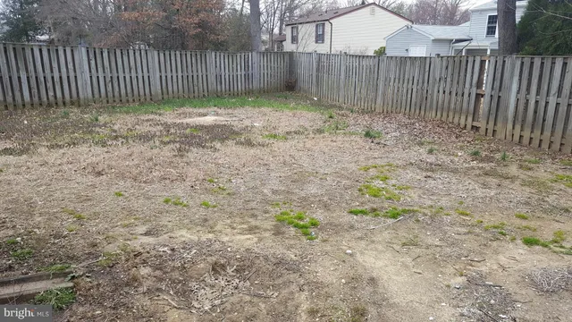 a view of a backyard with wooden fence