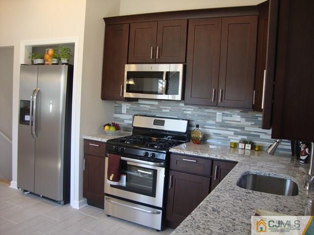 90 Westminster Road Colonia, NJ 07067 - Photo 8 of 25 a kitchen with stainless steel appliances granite countertop a stove microwave and refrigerator