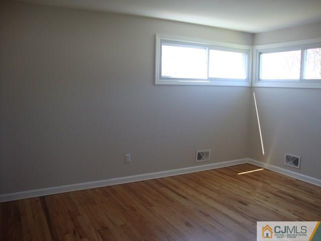 90 Westminster Road Colonia, NJ 07067 - Photo 9 of 25 an empty room with wooden floor and windows