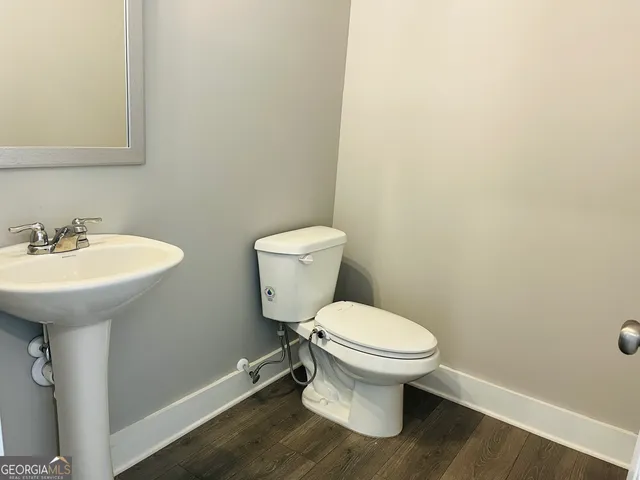 a bathroom with a toilet sink and mirror