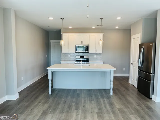 a view of kitchen with wooden floor and electronic appliances