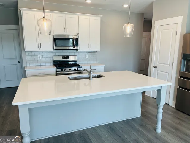 a kitchen with a appliances a stove a microwave and cabinets