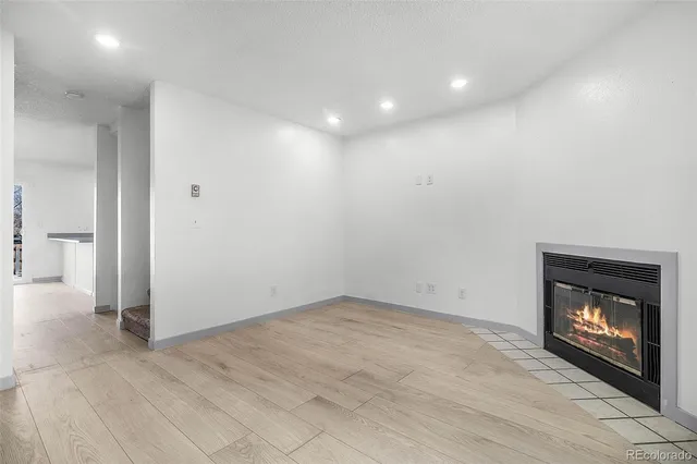 an empty room with a fireplace and outdoor view