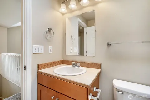 a bathroom with a sink toilet and a mirror