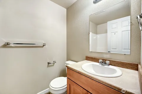 a bathroom with a sink a toilet and a mirror