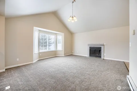 an empty room with windows and fireplace