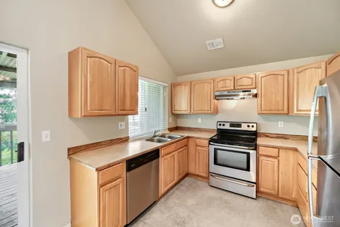 a kitchen with stainless steel appliances granite countertop a sink stove and microwave