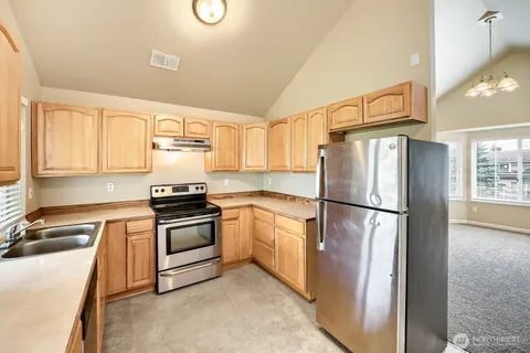a kitchen with a refrigerator sink stove and cabinets