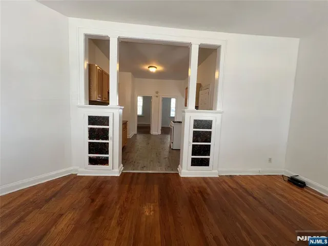 an empty room with wooden floor and cabinet
