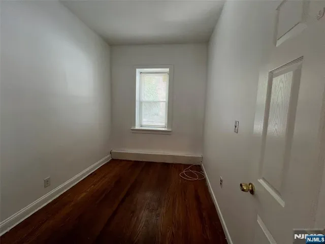 a view of a room with wooden floor and a window