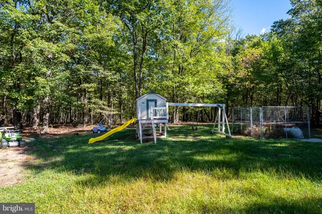 a living room with furniture and a refrigerator