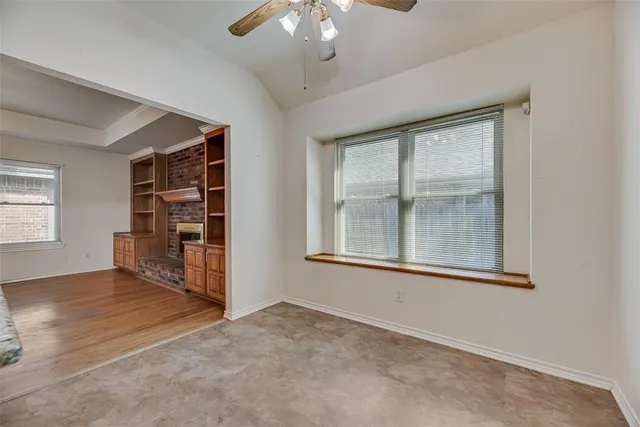 an empty room with windows and cabinet