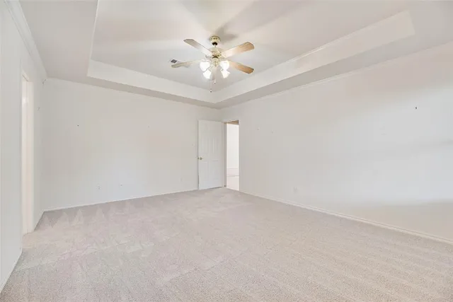 a view of an empty room with chandelier fan
